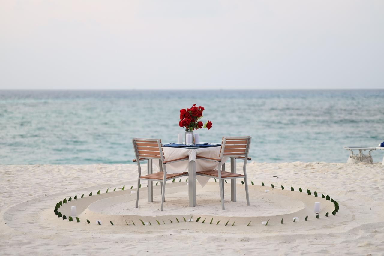 Candlelit dinner table set for two with mountain views at dusk